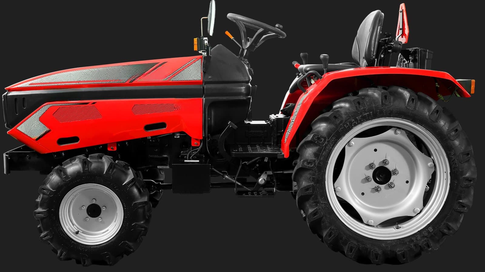 Side profile of a red electric compact tractor, showing the battery bonnet, operator platform and rear wheels